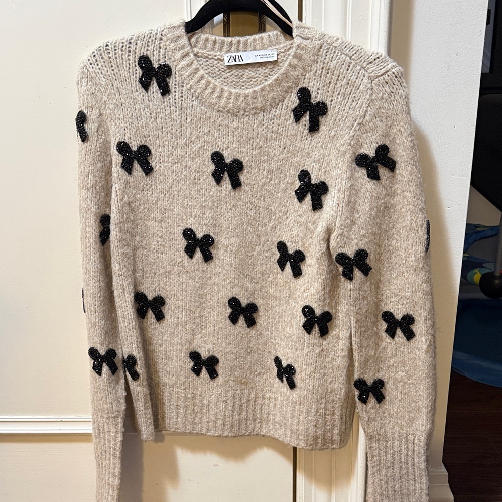 Beige sweater with sequin black bows